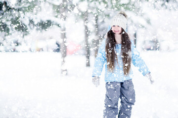 Fototapeta na wymiar Happy smiling girl kid in motion playing winter outdoor games.