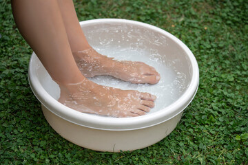 Woman taking footbath in a washbowl
