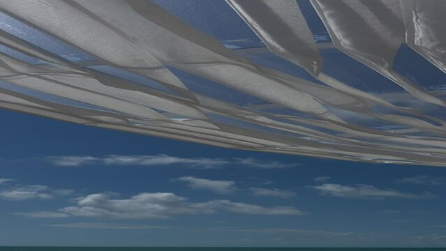 blue sky and flying white fabric