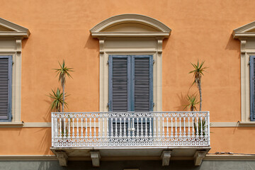 Balcone  con frontone ad arco persiane e balaustra con colonnine in ferro