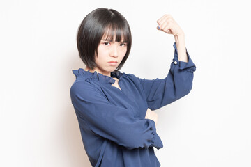 白背景の前に立って、怒っている若い女性