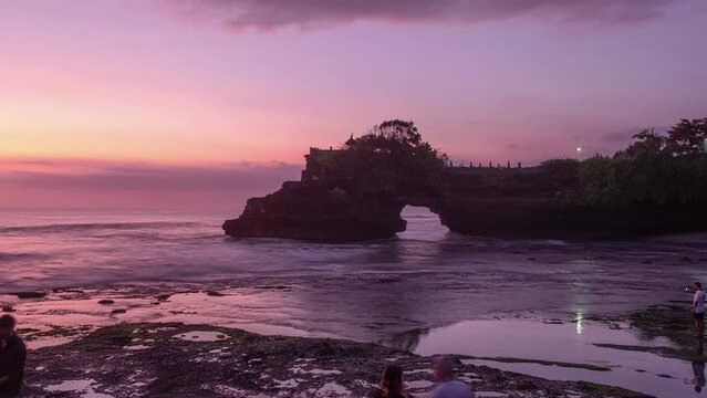 Beautiful sea with Pura Batu Bolong temple on rock cliff at sunset