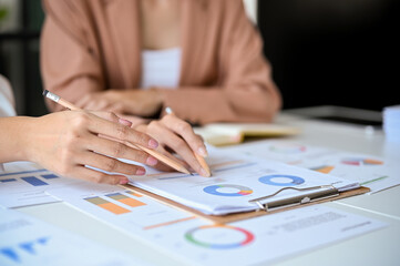 A team of professional business and financial analysts analyzing a financial data on the report