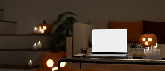 Modern living room in Halloween night with laptop mockup and Halloween decor on coffee table