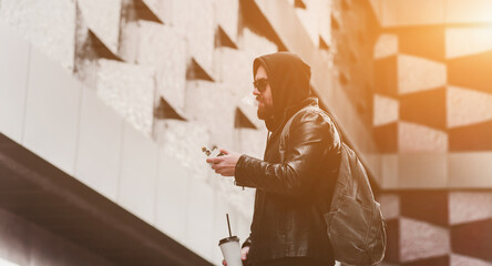 Fashion male dressed in leather jacket vaping.