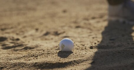 Golf player hitting the ball with his club
