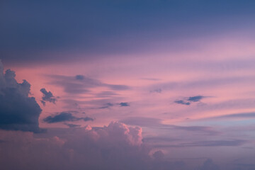 Light pink clouds in sunset blue sky. Pastel colors of clouds, sunrise sundown natural background