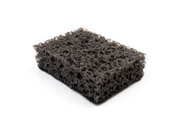 Black sponge used for washing dishes. Has two surfaces which are rough and smooth.