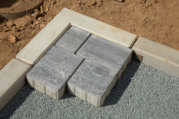  Laying gray concrete paving slabs in the courtyard of the house on a sandy foundation.