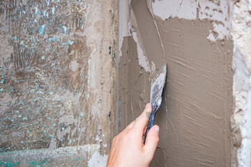 close up hand worker plastering cement on wall for building house