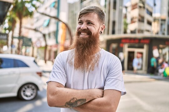 Young redhead man smiling confident standing with arms crossed gesture at street