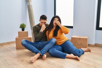 Young couple sitting on the floor at new home tired rubbing nose and eyes feeling fatigue and headache. stress and frustration concept.