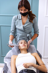 Young beautiful girl during cosmetic procedures in the beautician's office. Spa, beauty, wellness,...