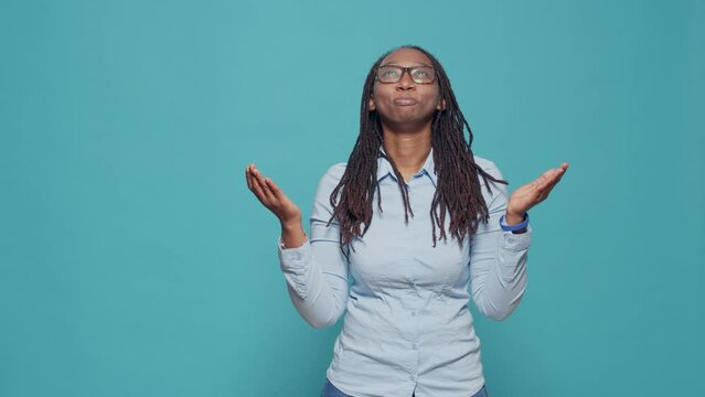 Female person begging for good luck and fortune, asking god for desire and wish. Praying and hoping for request, doing prayer hands in front of studio camera. Dreaming and waiting in anticipation.