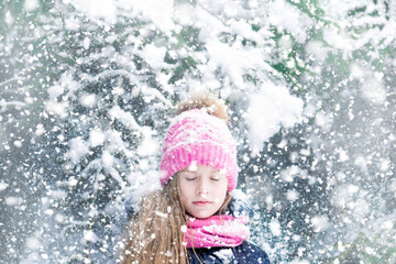 Portrait of girl's head in pink hat in snowy winter.