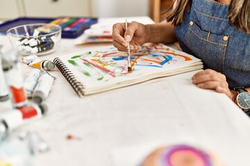Fototapeta premium Young hispanic artist woman smiling happy drawing at art studio.