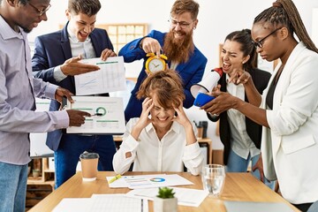 Group of business workers screaming to stressed partner at the office.