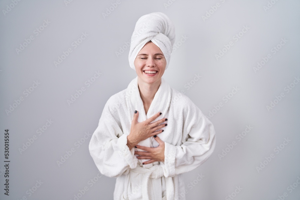 Sticker Blonde caucasian woman wearing bathrobe smiling and laughing hard out loud because funny crazy joke with hands on body.