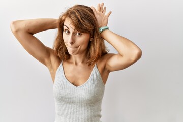 Fototapeta premium Beautiful caucasian woman standing over isolated background doing bunny ears gesture with hands palms looking cynical and skeptical. easter rabbit concept.