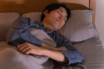ベッドで就寝する日本人男性