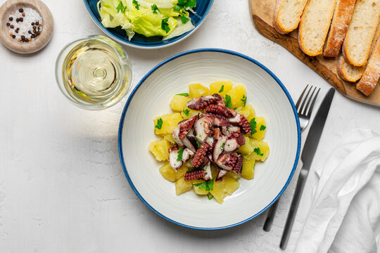  Italian Octopus and Potato Salad, salad and white wine glass. Insalata di polipo e patate. Top view.