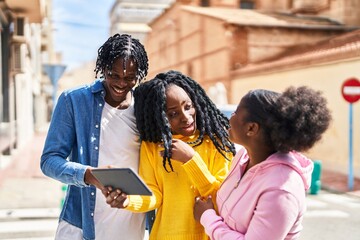 African american friends standing together watching video on touchpad at street