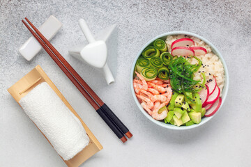 Hawaiian poke bowl with shrimp, cucumber, radish, avocado and chuka algae. Top view.
