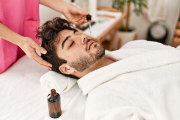 Man reciving skin face treatment at beauty center.