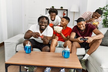 Group of african american people smiling happy playing video game at home.