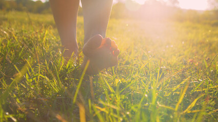 CLOSE UP, LOW ANGLE: Young female bare feet walking on grass in gorgeous light - obrazy, fototapety, plakaty