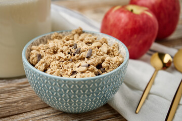 Granola with milk in blue bowl on wooden table, Healthy organic breakfast with muesli, Food clean eating concept