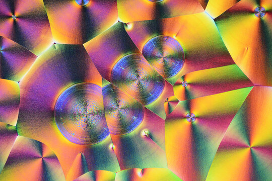 Colorful micro crystals in polarized light. Photo through a microscope.