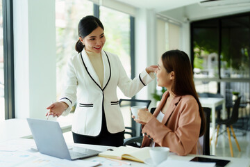 Portrait of two female employees using computers during work.