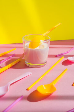 Ice cream sundae in a glass cup with a spoons among it in a pop art style on a vibrant background.