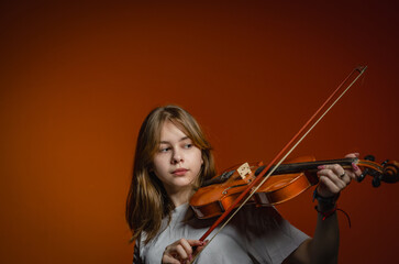 a girl with a violin on a dark background, wearing a white T-shirt