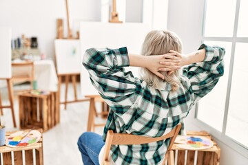 Young artist student girl on back view relaxed with hands on head at art studio
