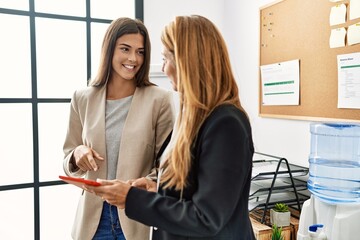 Mother and daughter business workers smiling confident using touchpad at office