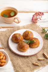 Traditional turkish dessert sekerpare with almonds and honey on white wooden, side view.