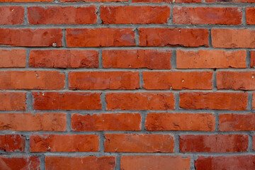 Obraz premium Fragment of old brickwork, close-up. Red brick wall. Potholes and defects in a brick wall. Flat lay, close-up. Cracks and defects of red brick on the wall. building houses, texture