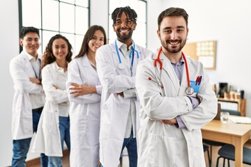 Fototapeta premium Group of young doctor smiling happy standing with arms crossed gesture at the clinic office.