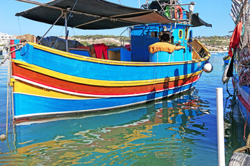 Fototapeta na wymiar colorful boat reflection at Marsaxlokk village Malta