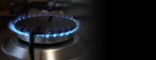 Banner of a close-up of a flame of methane gas stove in a domestic kitchen.