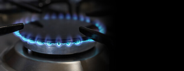 Banner of a close-up of a flame of methane gas stove in a domestic kitchen.