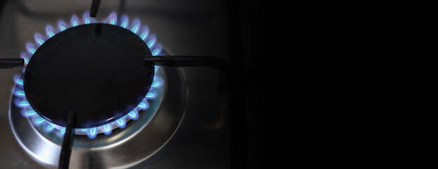 Banner of a close-up of a flame of methane gas stove in a domestic kitchen. - obrazy, fototapety, plakaty
