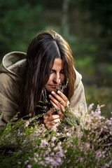 Young destitute woman gathers herbs