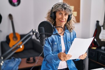Middle age woman singer singing song at music studio