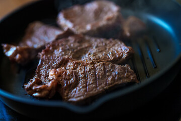 Beef steak with pepper is fried in a pan.