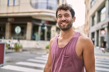 Young hispanic man smiling happy standing at the city.