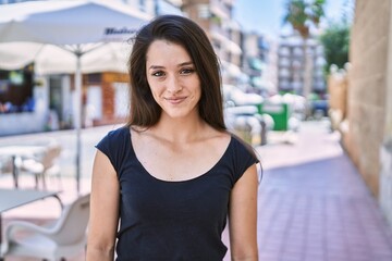 Young hispanic girl smiling happy standing at the city.