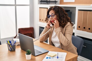 Obraz premium Middle age hispanic woman working with laptop at the office